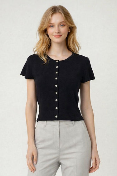 SaltTree model wearing a black short sleeve button-front knit cardigan with a round neckline and fitted waist.