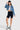 SaltTree model wearing an Enjean stone wash cropped denim jacket with a white crop top, black biker shorts, and boots.