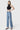 Model wearing SaltTree Flying Monkey high rise vintage flare jeans in medium wash with raw hem and slant side seam.