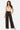Model wearing SaltTree Love Poem black ribbed wide-leg pants with an elastic drawstring waist and side pockets.