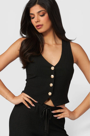 SaltTree Love Poem black waffle-knit button-front vest with gold buttons worn by a model