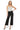SaltTree model wearing Mica Denim high rise wide leg cropped black jeans with a grey tank top and black heels.