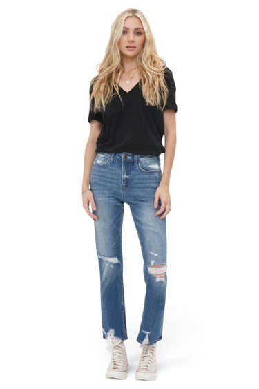 SaltTree model wearing Mica Denim high-rise straight jeans in vintage blue with distressed knees and raw side-slit hem.