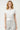 Model wearing a SaltTree off-white short sleeve button-front knit cardigan with a round neckline and fitted waist.