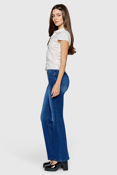 SaltTree model wearing ONE HUNDRED B high rise bootcut jeans in medium wash denim with a 32-inch inseam
