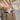SaltTree TOCOBO Cotton Airy Sun Stick SPF 50 being placed into a beige leather handbag on a city street.