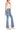 SaltTree model wearing Wax Jean low-rise medium blue bootcut denim jeans with a comfort-stretch potassium wash finish.