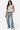 SaltTree model wearing a white sleeveless Love Poem boatneck jersey top paired with loose-fit blue denim jeans
