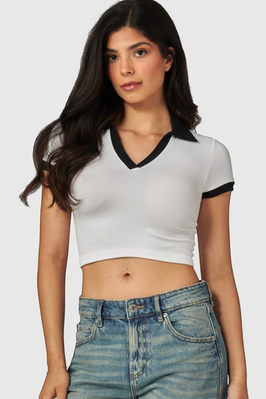 SaltTree model wearing a white Love Poem cropped polo top with black contrast collar and sleeves in seamless fabric.