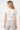 SaltTree model wearing a white short sleeve knit cardigan with a ribbed waist, viewed from the back.
