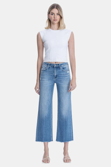 SaltTree medium wash high rise slim wide leg cropped jeans with raw hem and light distressing. Cotton blend.