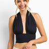 SaltTree ANWND black halter crop top with deep V-neck, shirred bust, and ribbed wide waistband worn by a smiling model