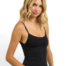 SaltTree model wearing a black ANWND seamless cami top with spaghetti straps and a shirred bust detail.