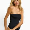 SaltTree model wearing a black ANWND strapless seamless tube top bodysuit with a smooth body-hugging fit.