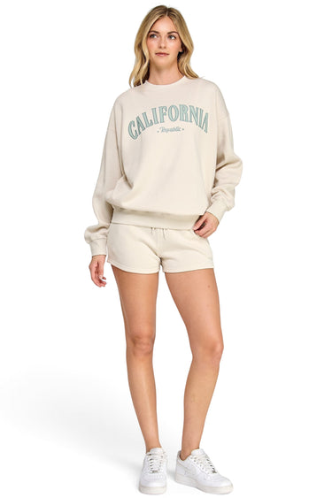 SaltTree model wearing a beige oversized fleece sweatshirt with California embroidery and matching shorts