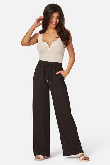 SaltTree model wearing black ribbed knit wide-leg pants with an elastic drawstring waist and side pockets