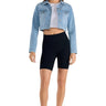 SaltTree model wearing an Enjean stone wash cropped denim jacket with a white crop top and black biker shorts