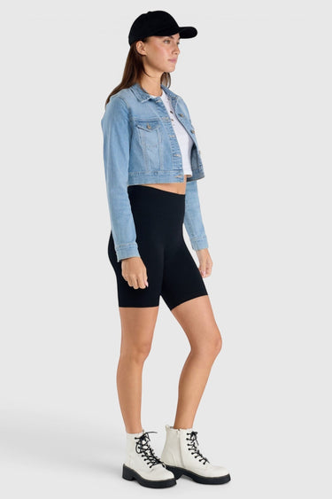 SaltTree model wearing an Enjean cropped light wash denim jacket with chest pockets and a black baseball cap