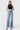 Model wearing SaltTree Flying Monkey high rise medium wash vintage flare jeans with slant side seams and raw hem.