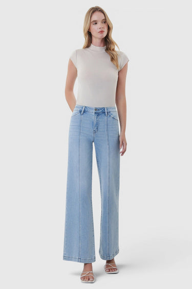 Model wearing SaltTree Flying Monkey high rise light wash wide leg jeans with cut seam detail and 31 inch inseam