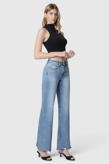 Model wearing SaltTree Flying Monkey high rise vintage flare jeans in medium wash with slant side seams and raw hem.