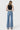 SaltTree model wearing Flying Monkey high rise vintage flare jeans in medium wash with a raw hem, back view.