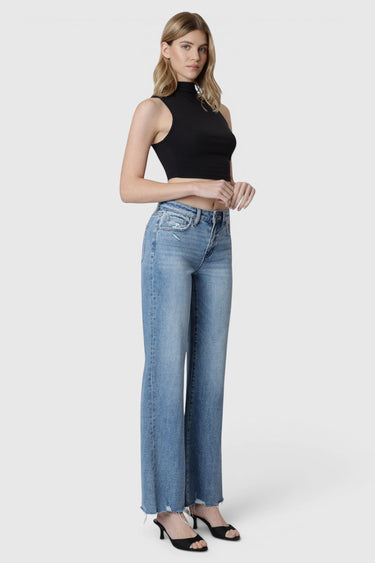 Model wearing SaltTree Flying Monkey high rise medium wash vintage flare jeans with slant side seams and raw hem.