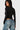 SaltTree Love Poem black long sleeve scoop neck bodysuit on a model wearing blue denim jeans, back view