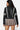 Model wearing SaltTree Love Poem black faux leather cropped moto jacket with white racing stripes, back view