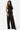 Model wearing SaltTree Love Poem black crinkled plisse crop top and wide-leg pant set with rhinestone embellishments.
