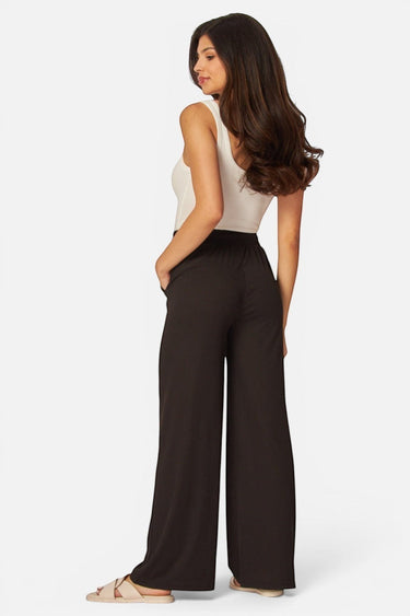 Model wearing SaltTree Love Poem black ribbed wide-leg pants with drawstring waist and side pockets, back view