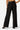 SaltTree Love Poem black high-rise wide-leg scuba knit pants with a belted waist, viewed from the back.