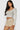 SaltTree model wearing taupe Love Poem lace bloomer shorts with ruffle frills and a white ribbed long-sleeve crop top