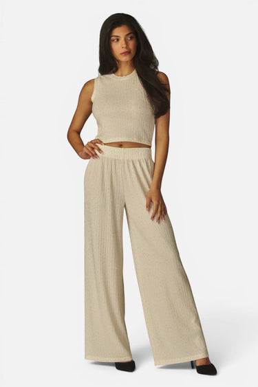 Model wearing SaltTree Love Poem off-white crinkled plisse crop top and wide-leg pants with rhinestone details.