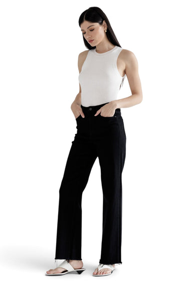 SaltTree Mica Denim high-rise slim wide-leg jeans in solid black with a raw hem worn by a model in a white tank top.