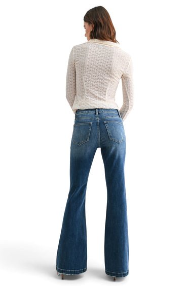 SaltTree model wearing Mica Denim high-rise flared jeans in vintage wash with back pocket detail and long inseam