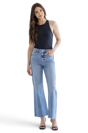 Model wearing SaltTree Mica Denim super high rise wide leg jeans in medium blue wash with a raw hem and 5-pocket style