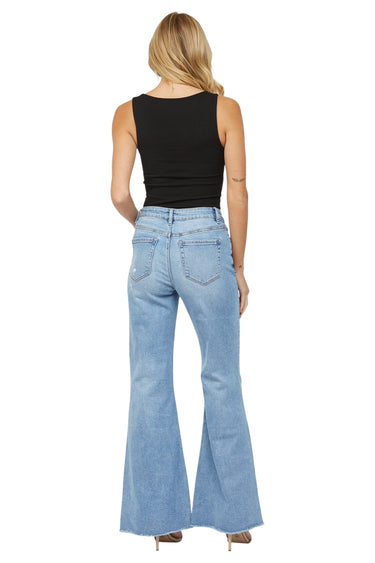 Model wearing SaltTree Mica Denim high rise super wide leg jeans in light wash with a raw frayed hem from behind