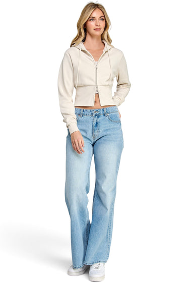 SaltTree model wearing a beige Reflex fleece cropped two-way zip-up hoodie with a drawstring hood and blue jeans