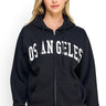 SaltTree Reflex black oversized fleece zip-up hoodie with white Los Angeles varsity print on a model