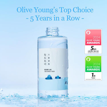 SaltTree Round Lab 1025 Dokdo Toner in a clear bottle with award badges on a blue water-splashed background