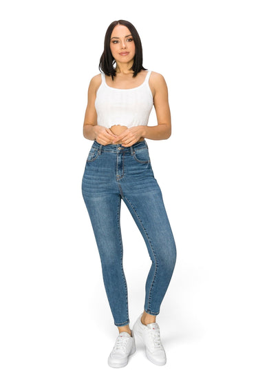 SaltTree model wearing Wax Jean high-rise skinny denim jeans in medium blue with a white crop top and sneakers