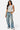 SaltTree model wearing a white sleeveless Love Poem boatneck jersey top paired with loose-fit blue denim jeans