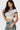 SaltTree model wearing a white cropped polo top with a black contrast collar and short sleeves in seamless fabric.