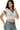 SaltTree model wearing a white cropped polo top with a black contrast collar and short sleeves in seamless fabric.