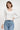 SaltTree model wearing a white long sleeve cropped cardigan with a scalloped edge and ribbed knit texture.